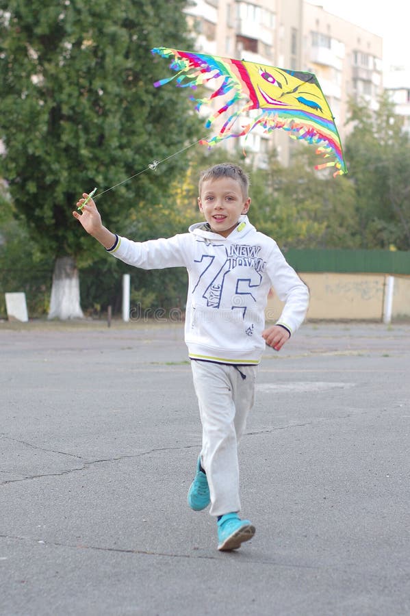 Funny and happy children play in a kite. They are dressed in white sweatshirts and pants. Running on the sunset stock photos Funny and happy children play in a kite. They are dressed in white sweatshirts and pants. Running on the sunset stock photos