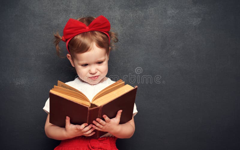 Fată amuzantă și fericită din școală cu cărți de pe tablă royalty free stock photo