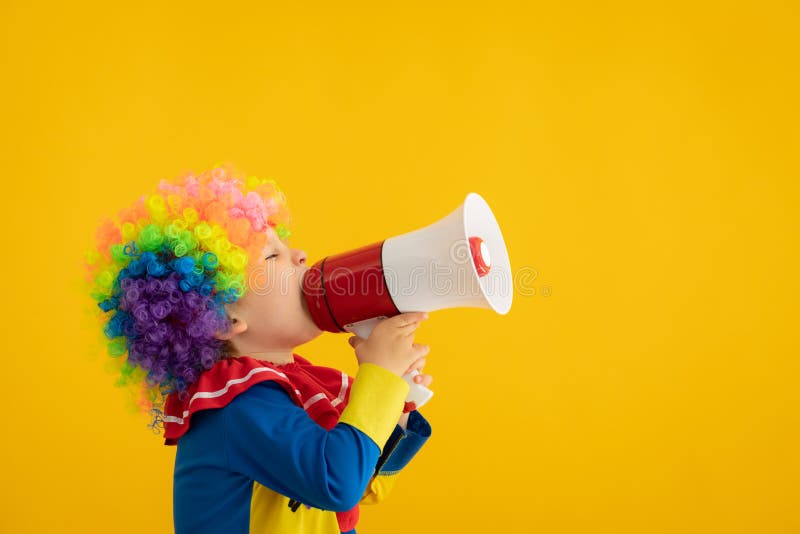 Funny kid clown playing against yellow background royalty free stock image Funny kid clown playing against yellow background royalty free stock image