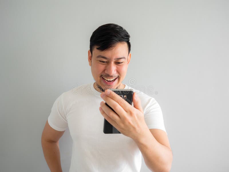 Funny laugh face of man watching funny video clip share in social in the smartphone. royalty free stock photo Funny laugh face of man watching funny video clip share in social in the smartphone. royalty free stock photo