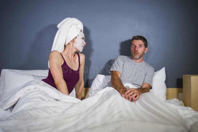 Funny Lifestyle Portrait of Man and Woman Featuring Weird Married Couple with Wife in Head Towel and Makeup Face Mask Demanding Se Stock Image