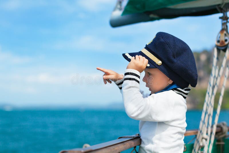 Funny little baby captain on board of sailing yacht