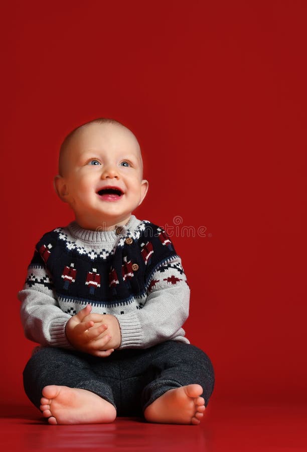 Funny little baby wearing warm knitted Christmas sweater at studio on cold winter day. royalty free stock photo Funny little baby wearing warm knitted Christmas sweater at studio on cold winter day. royalty free stock photo