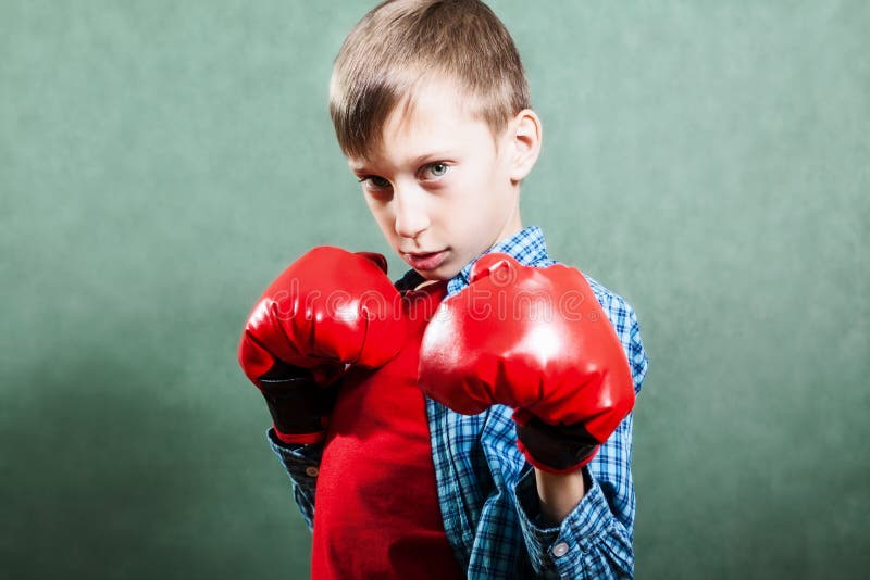 Funny little child with boxer gloves fighting looking dangerous