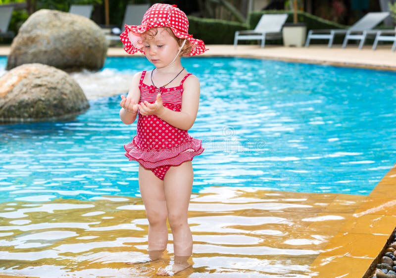 Funny little child girl near swimming pool on tropical resort in Thailand, Phuket. Summer vacations and sport concept