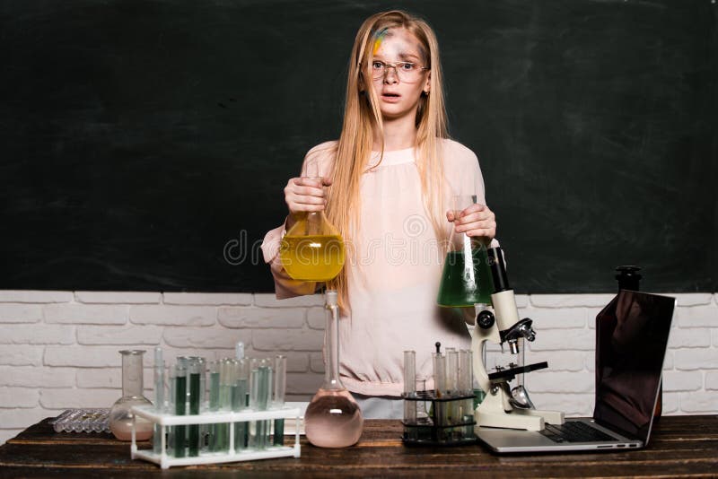 Funny little school child doing experiments in the laboratory. Explosion in the lab. Little girl scientist in the laboratory. Chemical experiment. School kid or scientists studying science