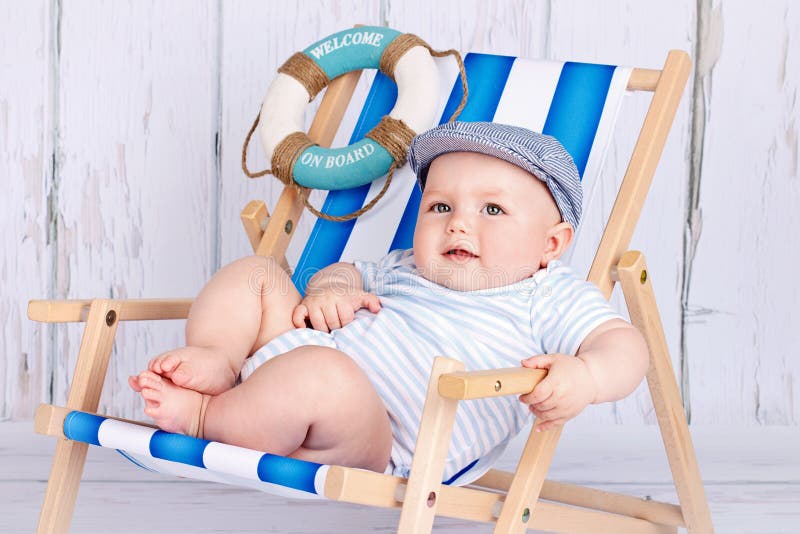 Funny little toddler sitting on the deckchair