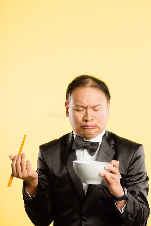 Funny looking Asian man eating and pulling faces. Funny looking Asian man eating and pulling faces