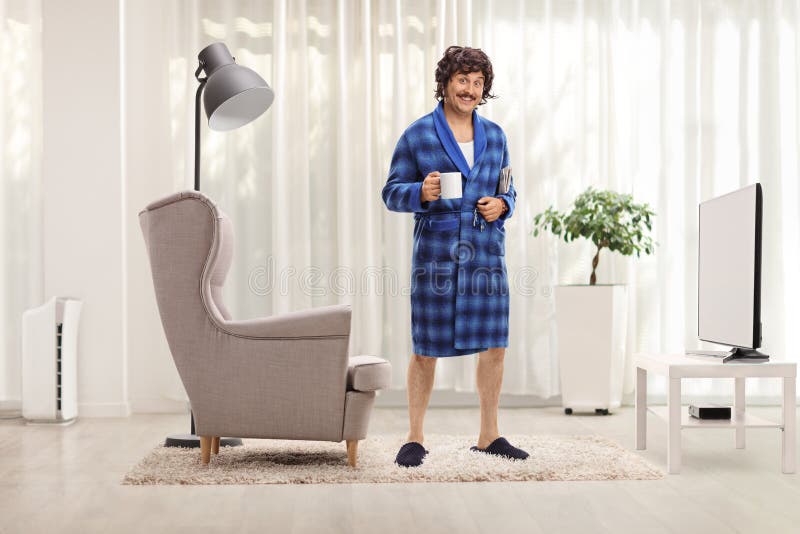 Funny Man in a Blue Bathrobe Holding a Cup at Home Stock Photo Image