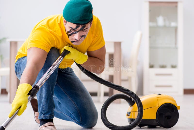 The funny man in military style cleaning the house