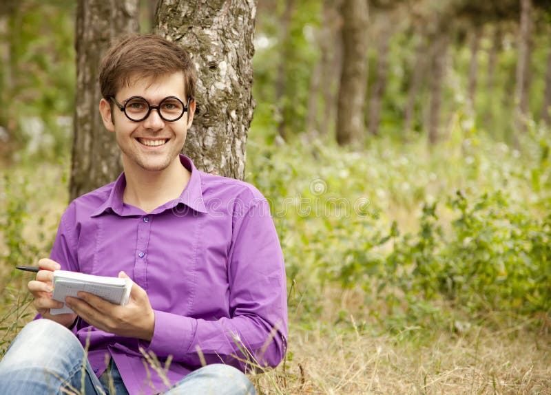 Funny men with glasses doing homework at the park