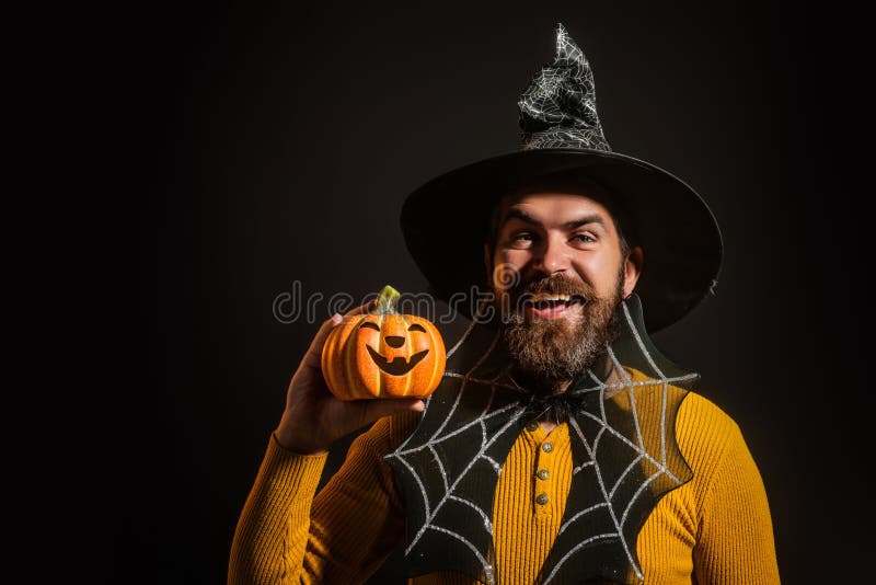 Funny modell med Halloween-pumpkin. Porträtt av Man i Halloween-hatt med pumpkin. Lås eller behandla. Scary hipster med skägg in arkivfoto
