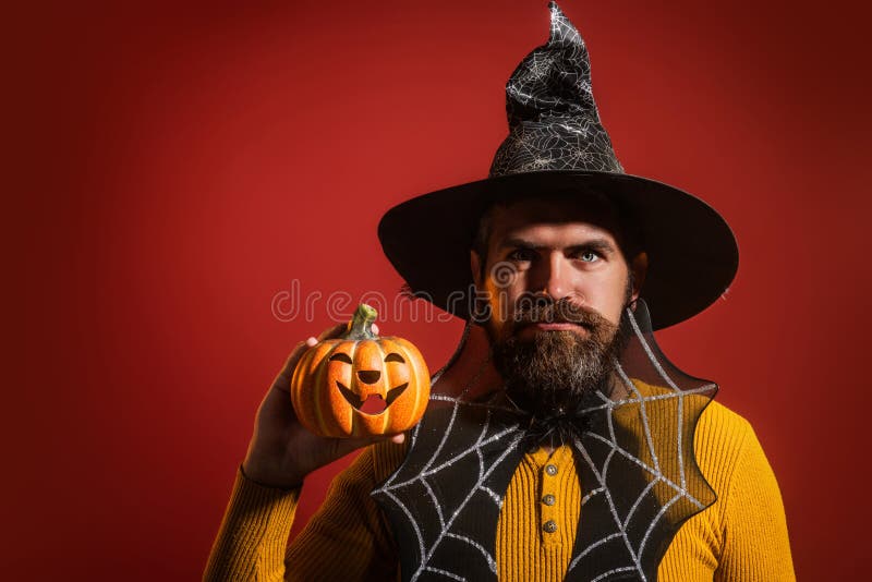 Funny modell med Halloween-pumpkin. Porträtt av Man i Halloween-hatt med pumpkin. Lås eller behandla. Scary hipster med skägg in royaltyfria foton