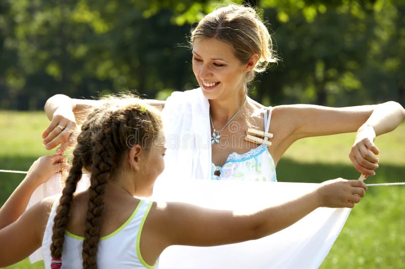 Funny mom and daughter hanging clothes