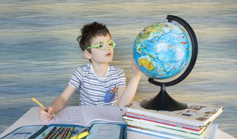 Funny Nerdy Student in Round Glasses Sits at a Desk and Examines the Globe  in a Geography Lesson. the Child Went To School in Stock Image - Image of  development, caucasian: 180625457