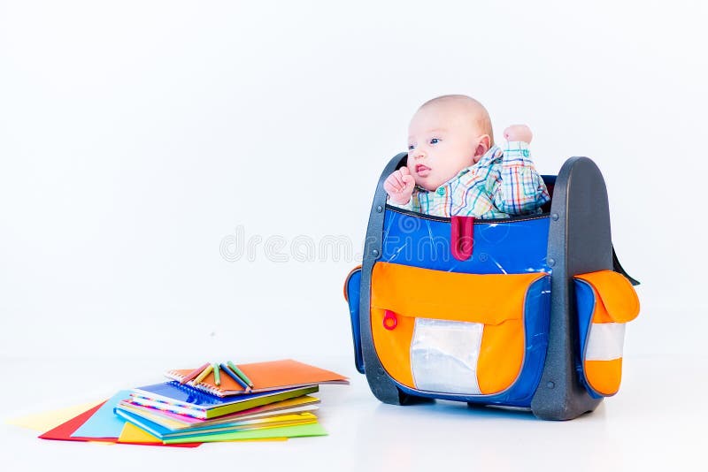 Funny newborn baby in a school backpack stock photo