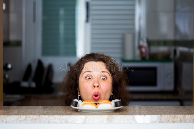 Funny picture of woman with Sushi at the kitchen. Fun, joke and humor concept.