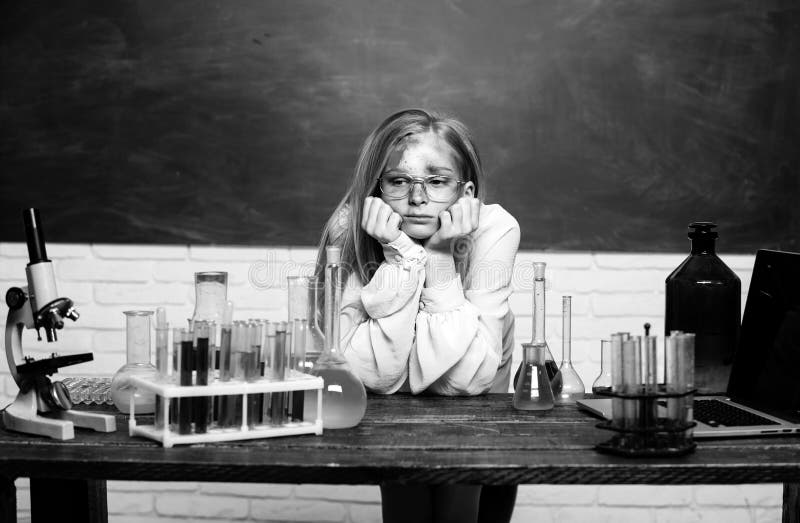 Funny sad schoolgirl scientist in the laboratory. Chemical experiment. Funny schoolgirl kid doing experiments in the chemistry laboratory. Explosion in the lab. Science and education