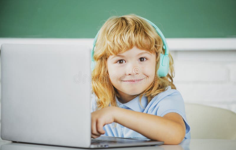 Funny School Kid Boy with Laptop Computer and Headphones in Class at ...