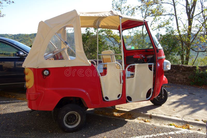 Funny small retro bright red three-wheeled convertible microcar royalty free stock photography Funny small retro bright red three-wheeled convertible microcar royalty free stock photography
