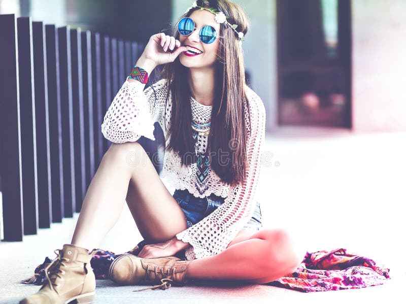 Beautiful young hippie woman model in summer white hipster clothes posing in the street