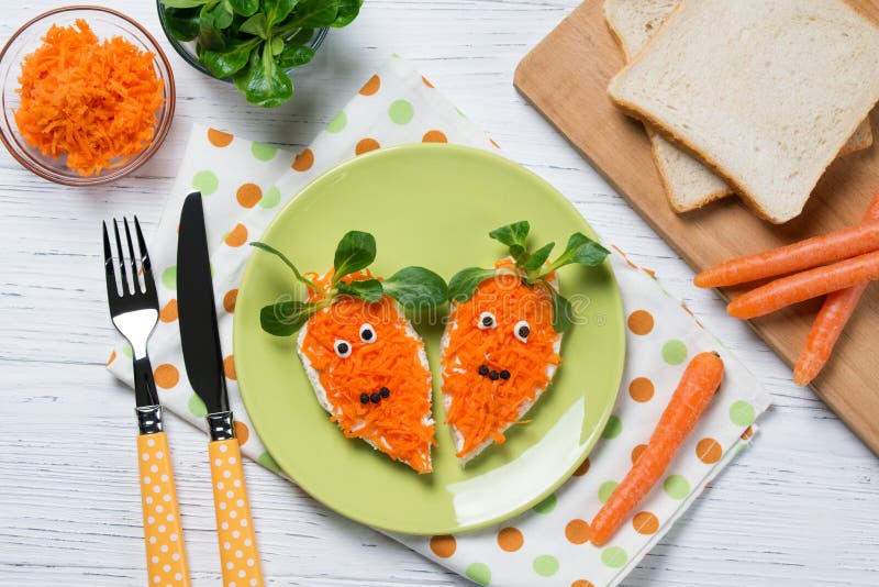 Funny toasts in a shape of carrots, food for kids Easter idea, top view