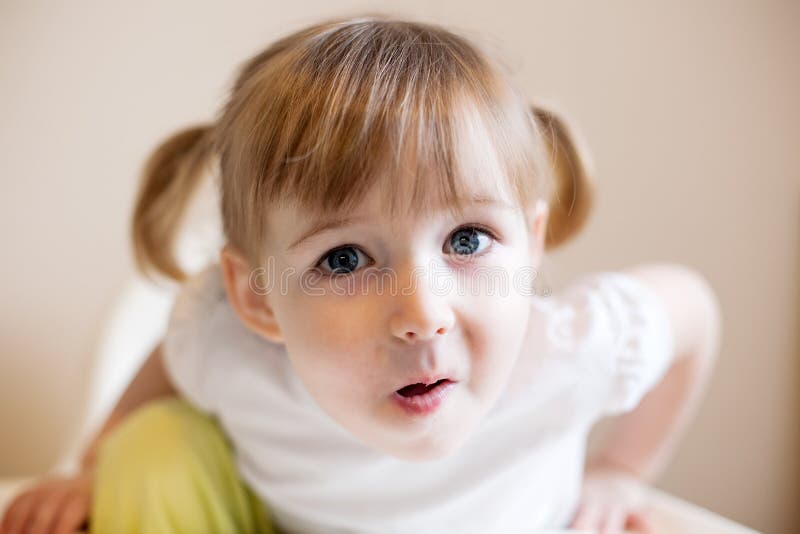 Funny two years old girl with two cute pigtails and quiff