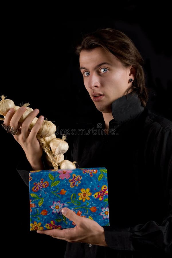 Funny vampire with gift box taking out garlic stock photos