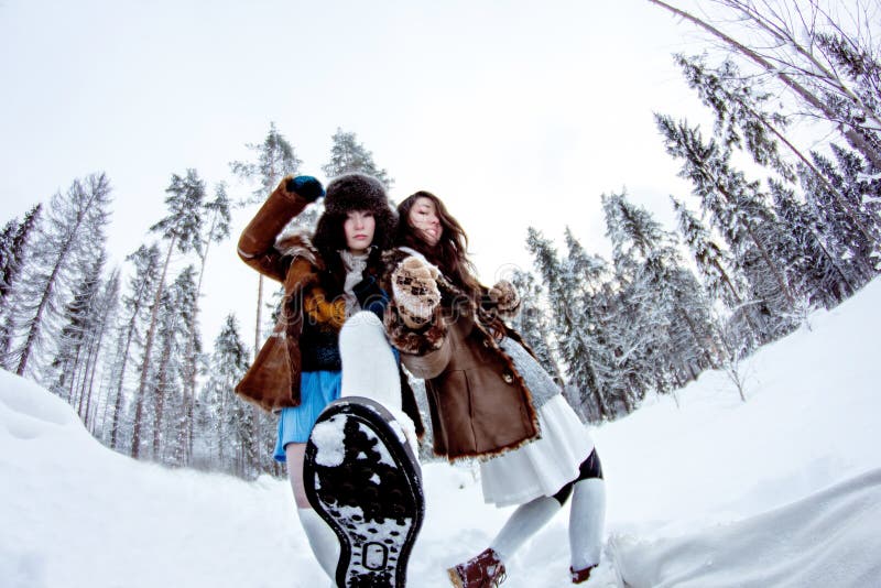 Funny women fooling around on white snow winter background fisheye