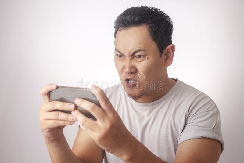 Funny Young Asian Guy Playing Games on Tablet stock images Funny Young Asian Guy Playing Games on Tablet stock images