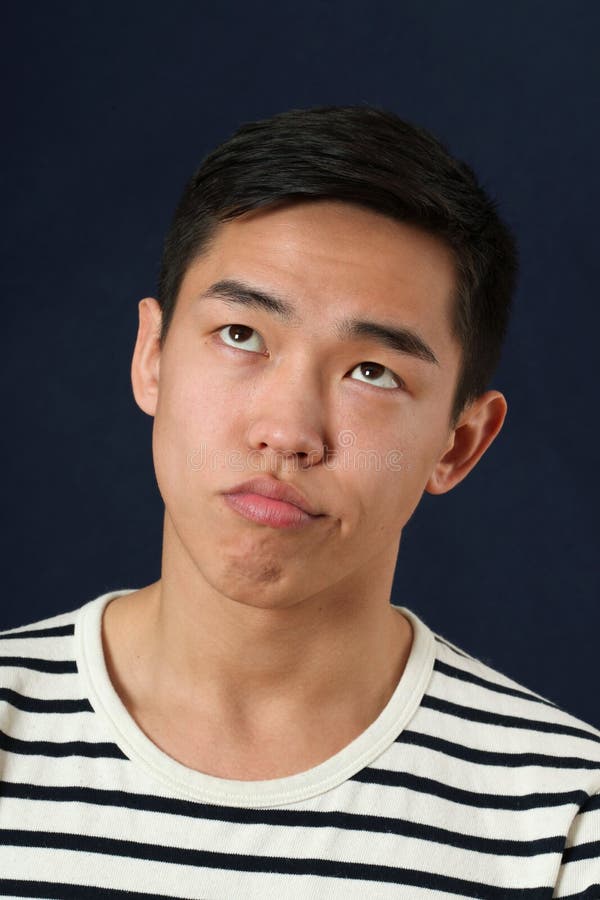 Funny young Asian man making face and rolling eyes up.