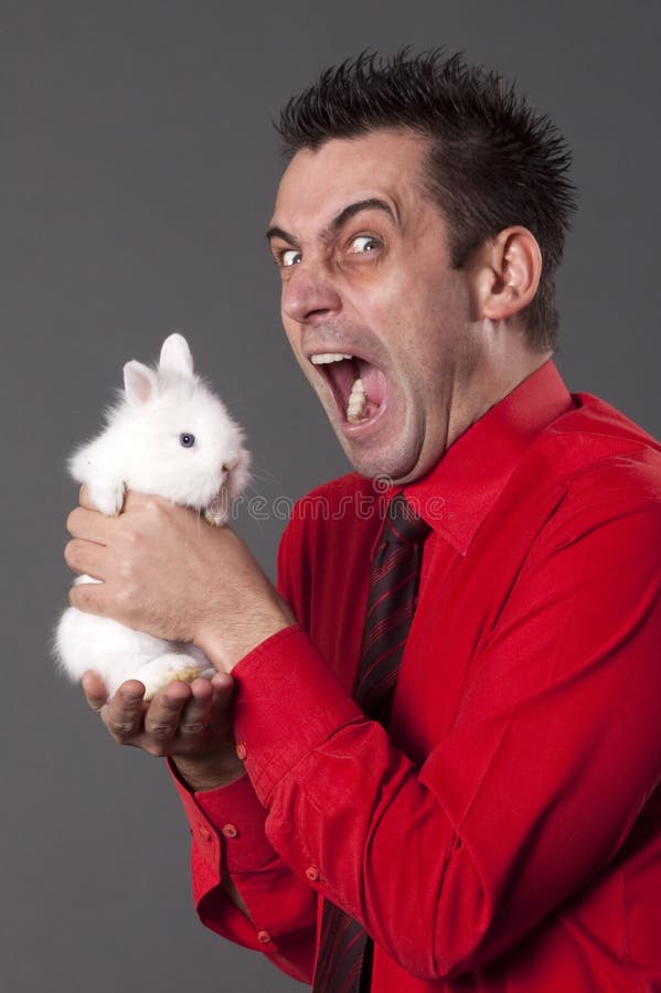 Funny young man holding white rabbit