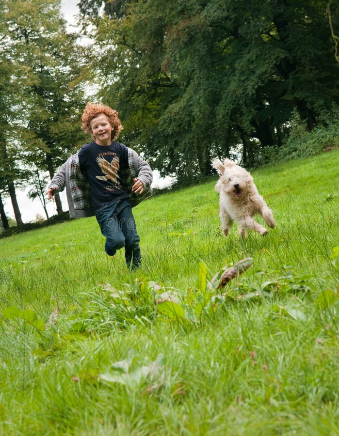 Funzionamento del cane e del bambino immagine stock libera da diritti Funzionamento del cane e del bambino immagine stock libera da diritti