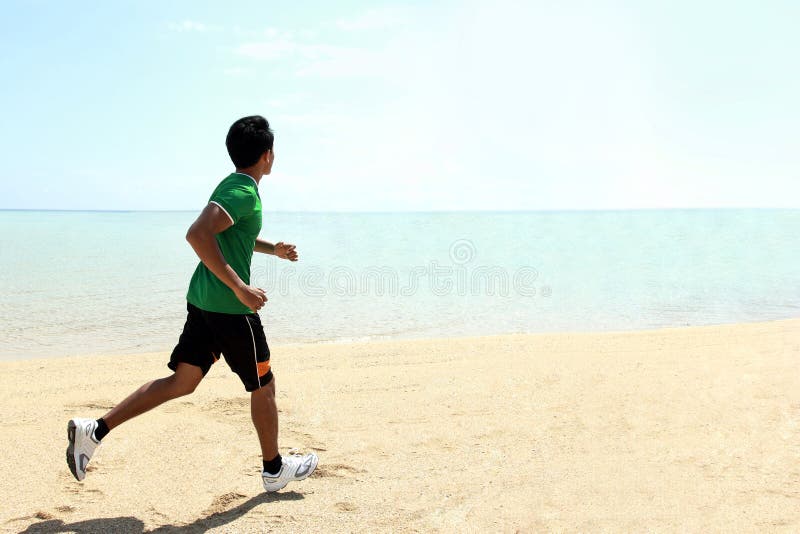 Funzionamento dell'uomo sulla spiaggia immagini stock libere da diritti Funzionamento dell'uomo sulla spiaggia immagini stock libere da diritti