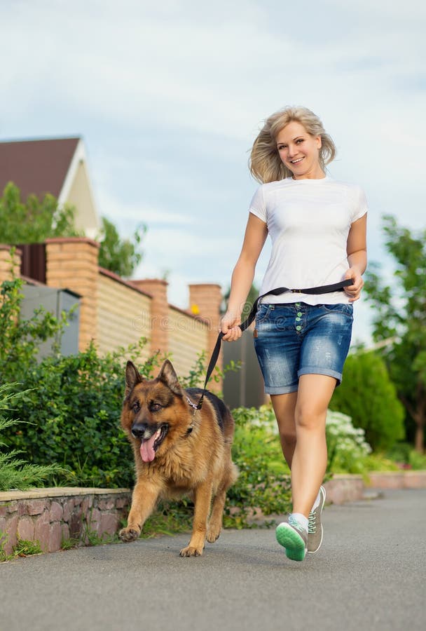 Funzionamento della donna con il suo cane fotografia stock Funzionamento della donna con il suo cane fotografia stock