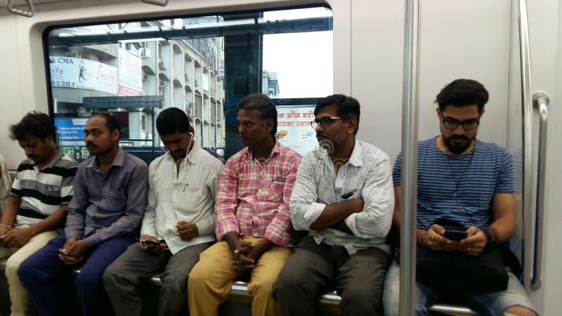 Funzionamento e pendolari del treno della metropolitana di Mumbai che si siedono & che stanno nella metropolitana fotografia stock libera da diritti Funzionamento e pendolari del treno della metropolitana di Mumbai che si siedono & che stanno nella metropolitana fotografia stock libera da diritti