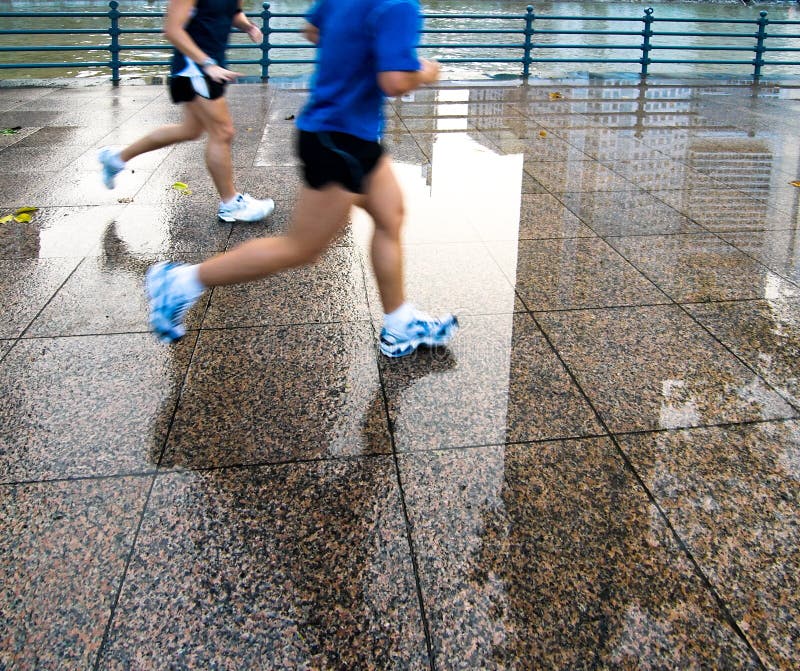 Runners along the banks of a river in the evening after a shower. Runners along the banks of a river in the evening after a shower