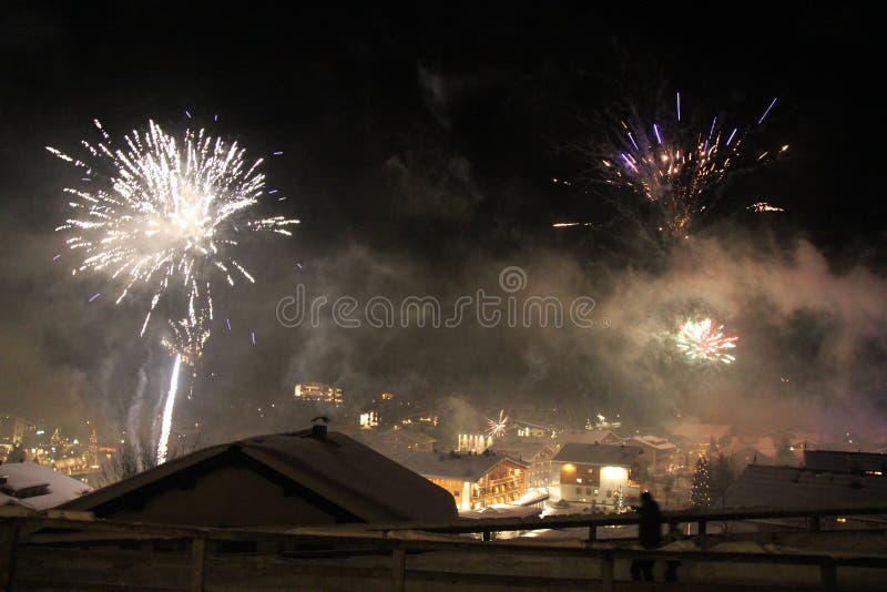 Fuochi d'artificio di Capodanno a Lech am Arlberg, panorama della montagna alpina austriaca immagine stock libera da diritti Fuochi d'artificio di Capodanno a Lech am Arlberg, panorama della montagna alpina austriaca immagine stock libera da diritti