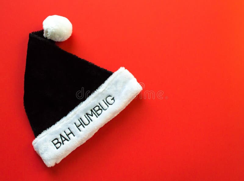 Fur brim of a hat with the words Bah Humbug on it in black and white isolated on a red background. Fur brim of a hat with the words Bah Humbug on it in black and white isolated on a red background