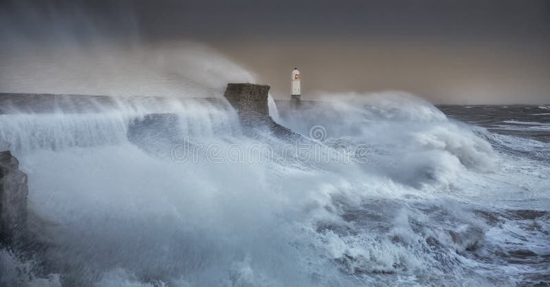 The forces of nature engulf the pier and lighthouse as Storm Brian lands on the Porthcawl coast of South Wales, UK. The forces of nature engulf the pier and lighthouse as Storm Brian lands on the Porthcawl coast of South Wales, UK.