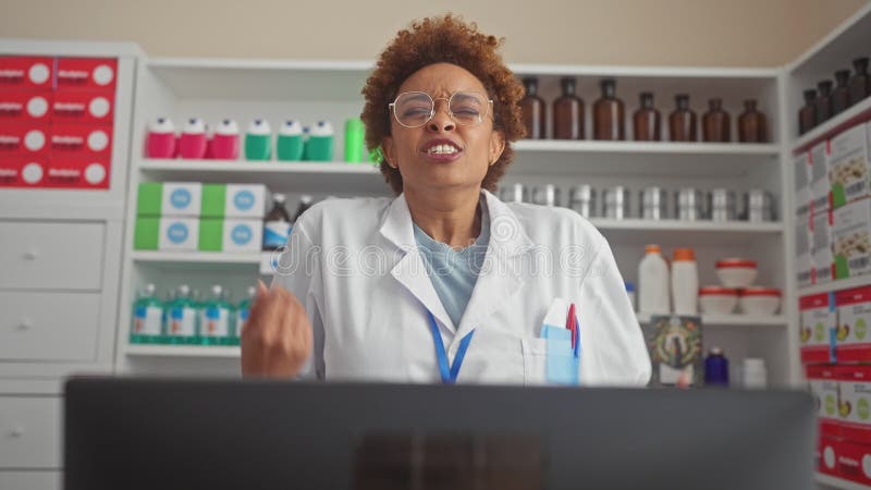 Furiosa mujer afroamericana con uniforme farmacéutico furiosa y frustrada gritando de rabia gritando fuerte a la farmacia metrajes
