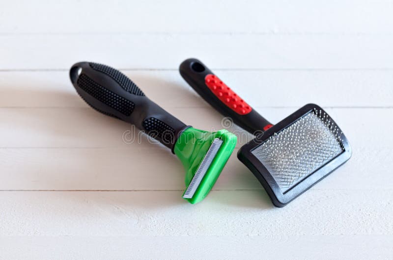 Furminators Grooming cats and dogs. Tools for the care of the animals on a white background stock images Furminators Grooming cats and dogs. Tools for the care of the animals on a white background stock images