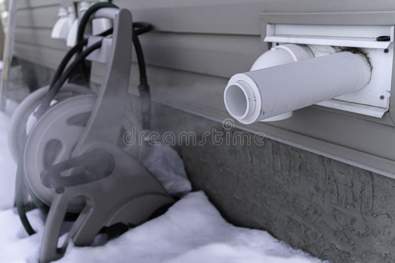 Furnace Exhaust Vent with Icicle from Dripping Water Stock Photo