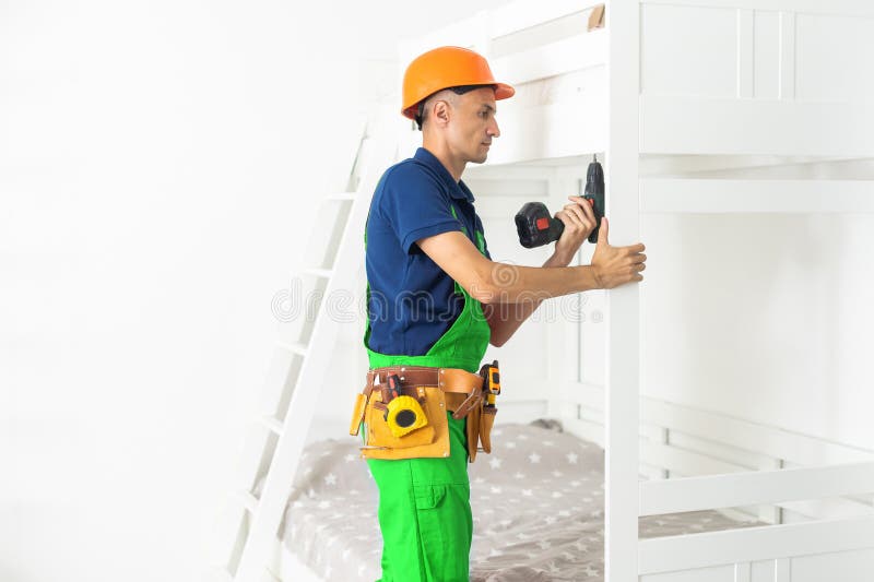 The Furniture Assembler Assembles the Bed, Twists the Screws on the