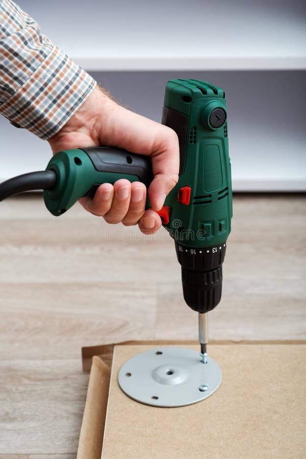 Furniture Assembly Using Drill. Male Hands Master Collects Furniture
