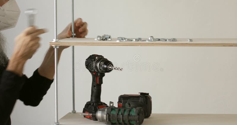 Furniture worker assembling plywood iron shelf