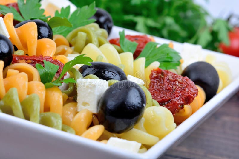 Fusilli with Dried Tomato, Olive and Cheese in a Plate Stock Image