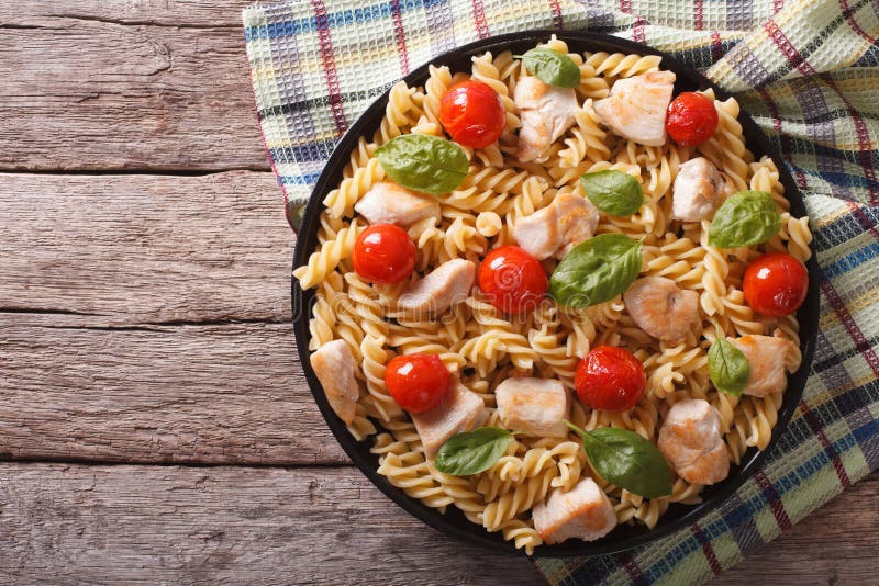 Fusilli pasta with chicken, tomatoes and basil on plate. horizon