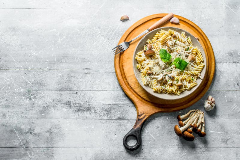 Fusilli pasta with mushrooms in a plate on a cutting Board