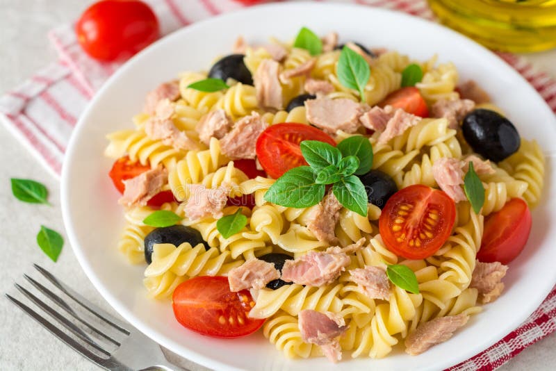 Fusilli Pasta Salad with Tuna, Tomatoes, Black Olives and Basil on Gray ...